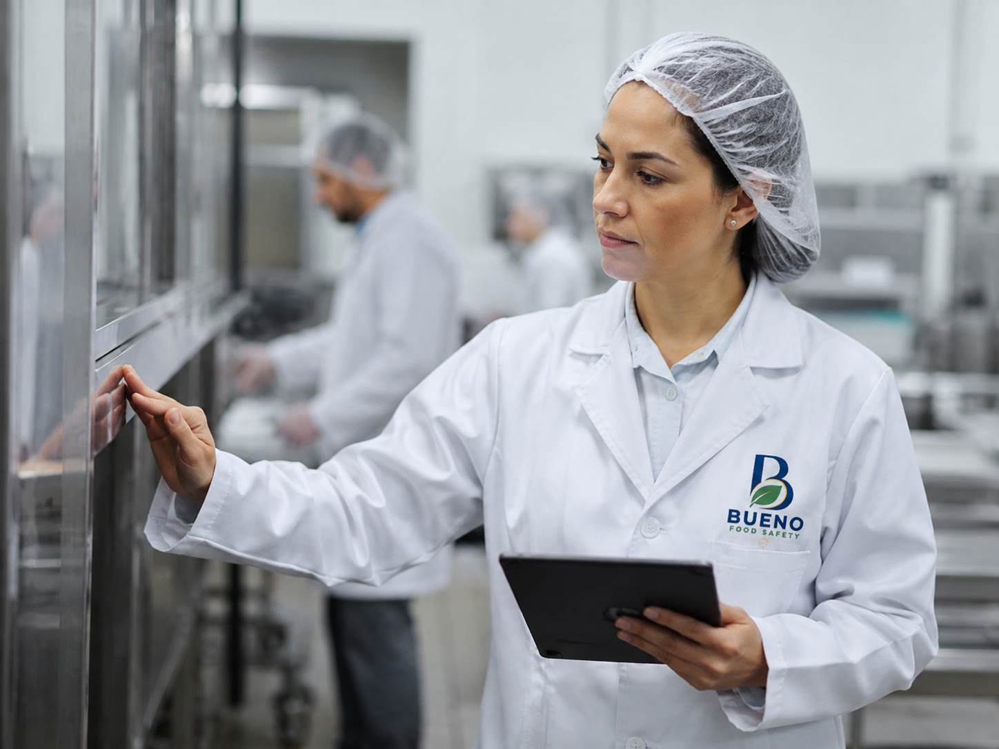 Consultora da Bueno Food Safety realizando auditoria higiênico-sanitária com checklist em tablet