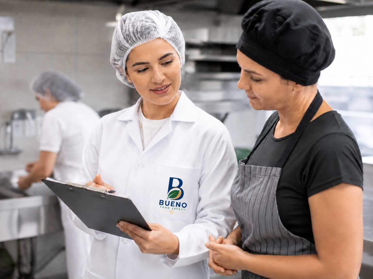 Consultora responsável técnica da Bueno Food Safety orientando colaboradora em cozinha profissional